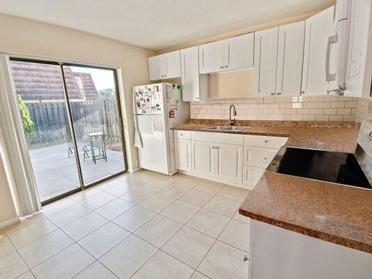 kitchen featuring white cabinetry, white fridge, sink, and stainless steel range with electric stovetop