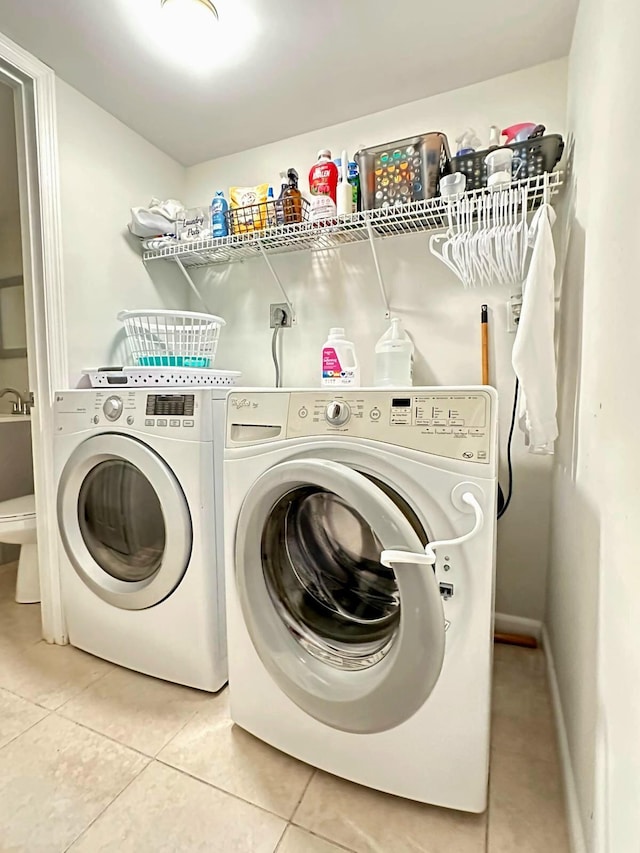 laundry room with washing machine and clothes dryer and tile patterned flooring