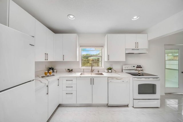 kitchen with sink, white appliances, a textured ceiling, and white cabinets