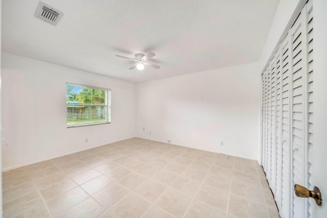 tiled spare room featuring ceiling fan