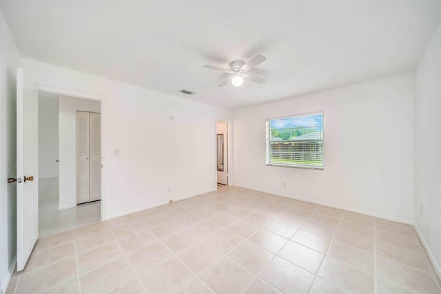 empty room featuring ceiling fan and light tile patterned floors