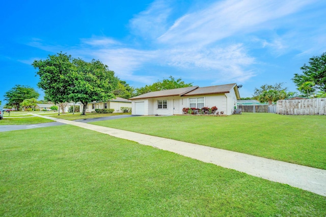 ranch-style home featuring a garage and a front lawn