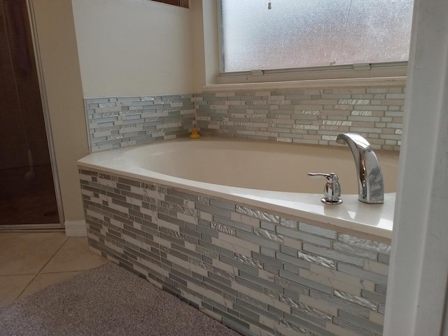 bathroom with a bath and tile patterned floors