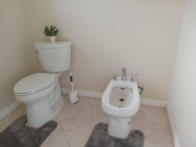 bathroom with a bidet, toilet, and tile patterned floors