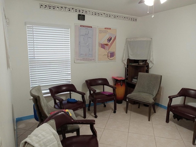 sitting room with ceiling fan and light tile patterned floors