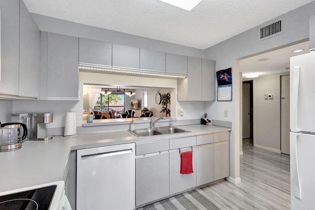 kitchen featuring dishwasher, white cabinetry, sink, white refrigerator, and range