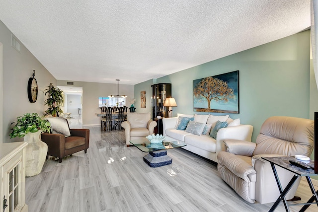 living room with a textured ceiling and light wood-type flooring