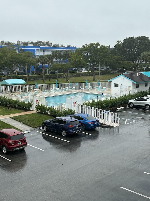 view of vehicle parking featuring a community pool