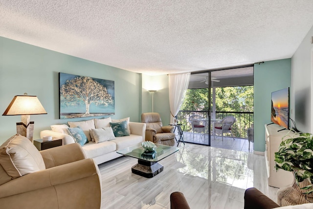 living room with a textured ceiling, a wall of windows, and light hardwood / wood-style floors