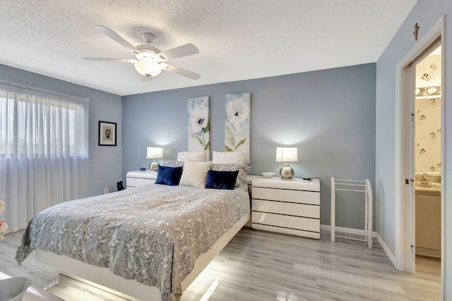 bedroom featuring ceiling fan, light hardwood / wood-style floors, and a textured ceiling