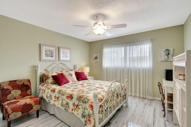 bedroom featuring ceiling fan, a textured ceiling, and light hardwood / wood-style floors