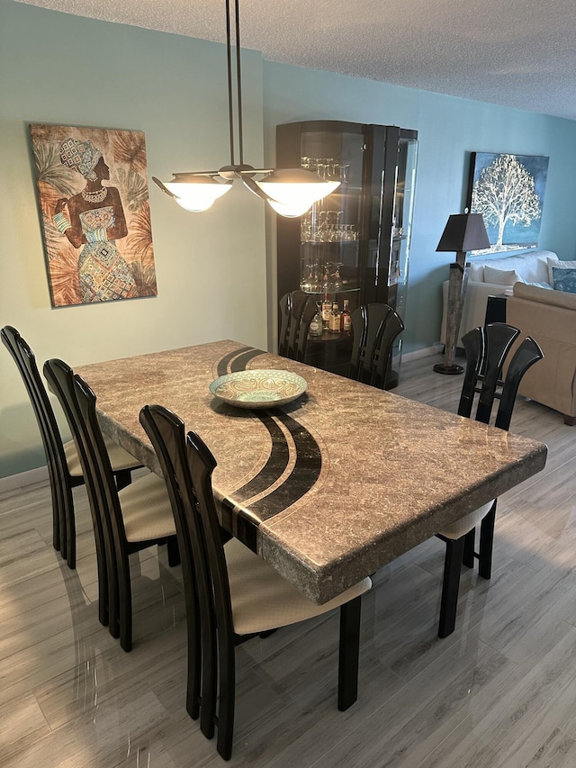 dining room with hardwood / wood-style floors and a textured ceiling