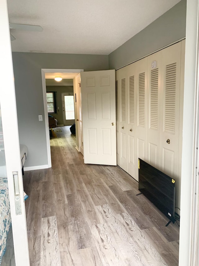 unfurnished bedroom featuring a closet, light hardwood / wood-style floors, and ceiling fan