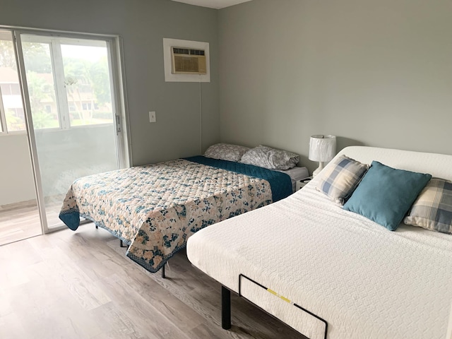 bedroom featuring access to exterior, light wood finished floors, baseboards, and a closet
