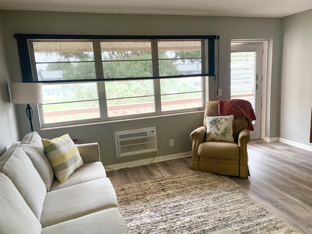 sitting room featuring an AC wall unit and light hardwood / wood-style flooring