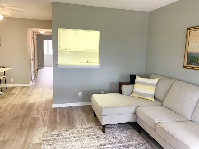 living room with ceiling fan and light hardwood / wood-style floors