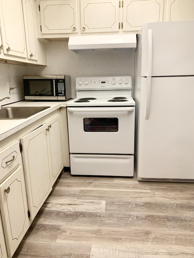 kitchen with ventilation hood, sink, white appliances, and light hardwood / wood-style flooring