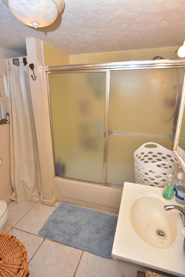 full bathroom with sink, enclosed tub / shower combo, a textured ceiling, tile patterned floors, and toilet
