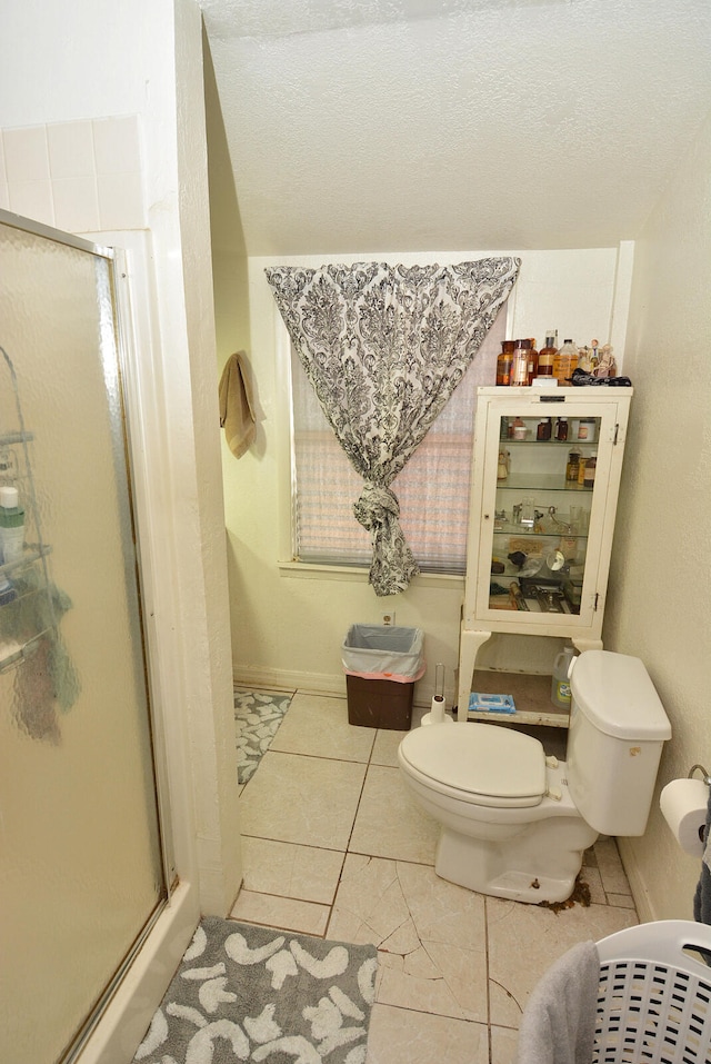 bathroom featuring walk in shower, toilet, and tile patterned flooring