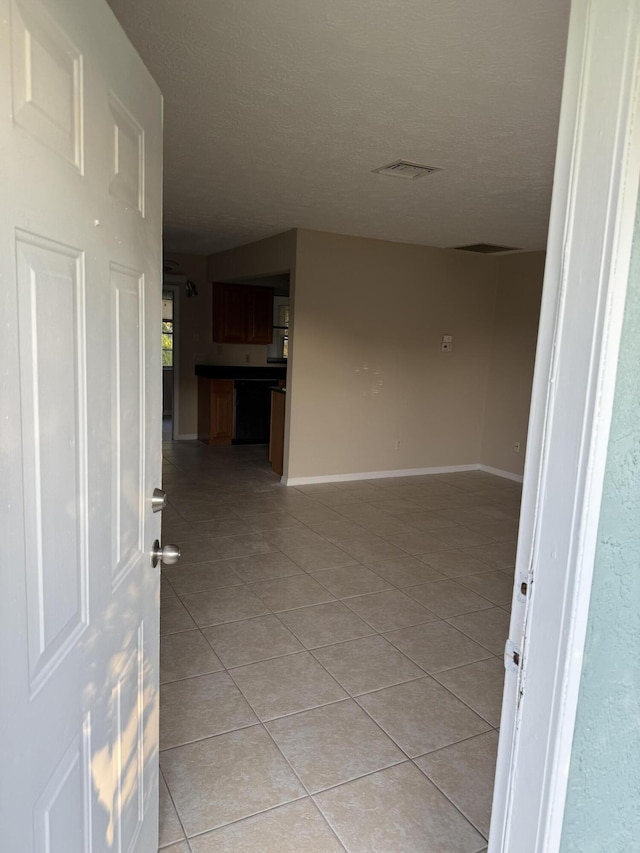 interior space featuring a textured ceiling and light tile patterned flooring