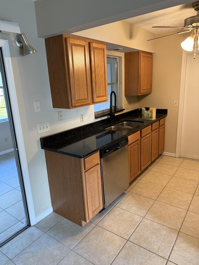 kitchen with a textured ceiling, stainless steel dishwasher, sink, ceiling fan, and light tile patterned floors