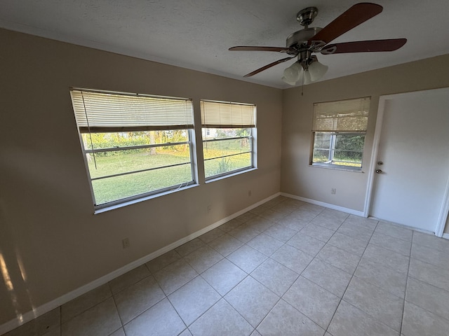 tiled spare room with a textured ceiling and ceiling fan