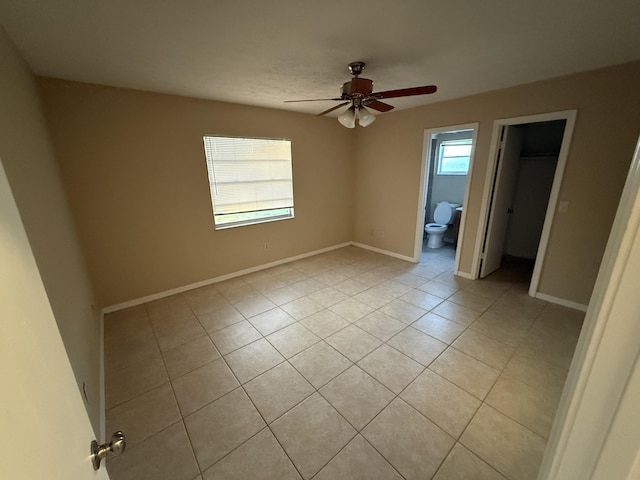 tiled spare room featuring ceiling fan