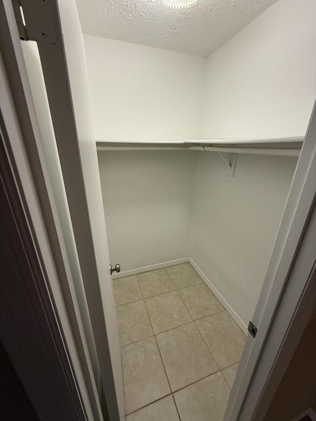 spacious closet with light tile patterned floors