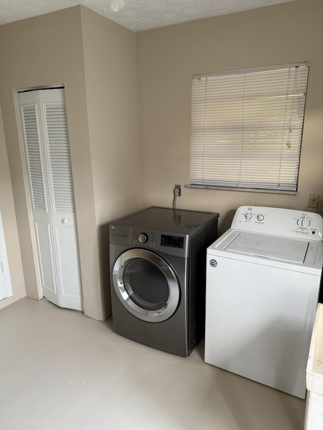 clothes washing area with separate washer and dryer