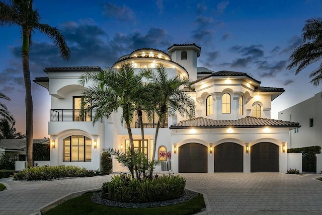 mediterranean / spanish-style house featuring a garage and a balcony