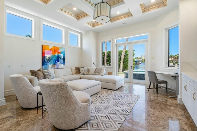 living room with coffered ceiling, a high ceiling, french doors, built in desk, and beam ceiling