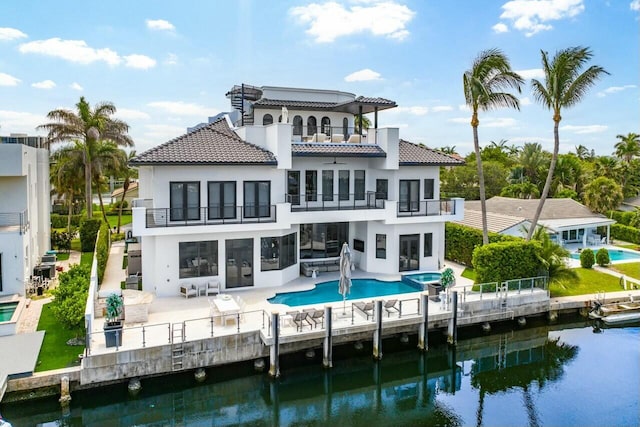 back of house featuring a balcony, a water view, and a patio