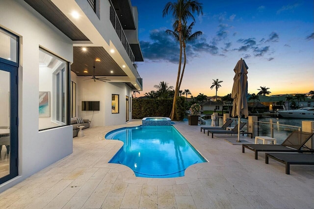 pool at dusk with an in ground hot tub, a patio area, and ceiling fan