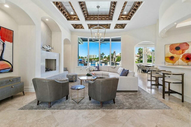 living room with a high end fireplace, beamed ceiling, a chandelier, and coffered ceiling