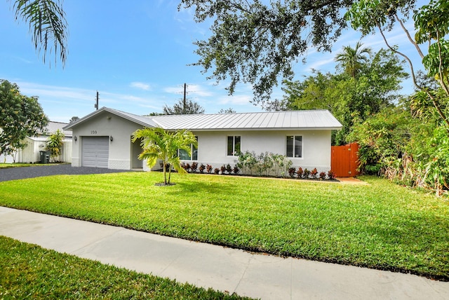 single story home featuring a garage and a front lawn