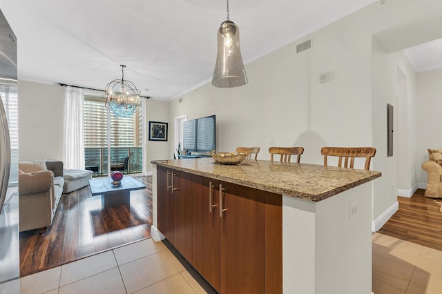 kitchen with pendant lighting, light tile patterned floors, and crown molding