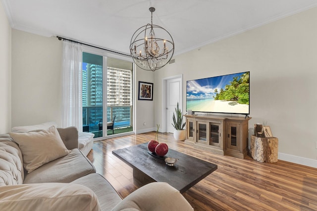 living room with crown molding, hardwood / wood-style floors, and a chandelier