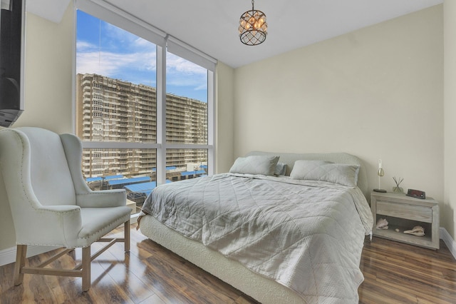 bedroom with dark hardwood / wood-style floors and expansive windows