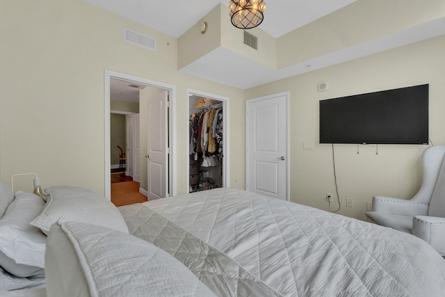 bedroom featuring an inviting chandelier, a closet, and a walk in closet