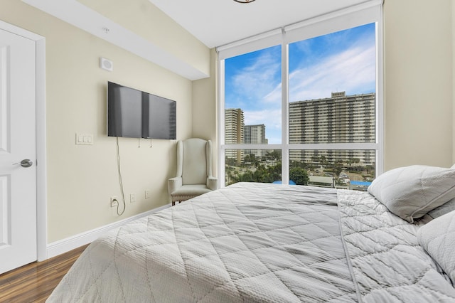 bedroom featuring hardwood / wood-style flooring, multiple windows, and expansive windows