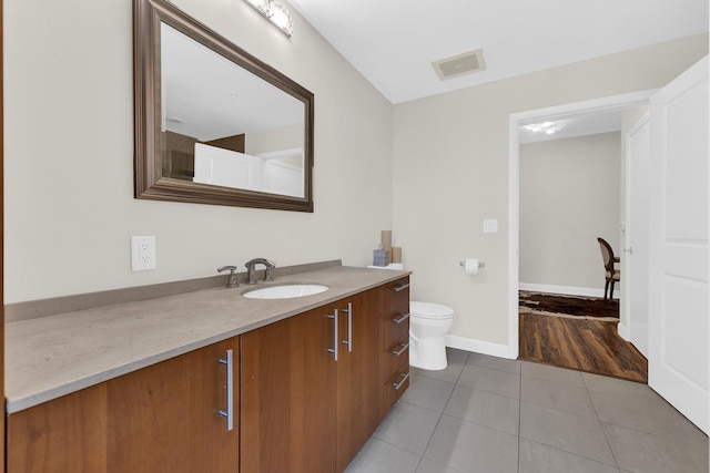 bathroom featuring toilet, vanity, and tile patterned flooring