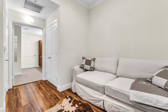 living area with hardwood / wood-style flooring and ornamental molding