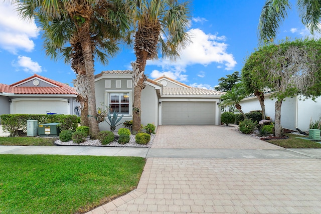 mediterranean / spanish-style home featuring a garage and a front lawn