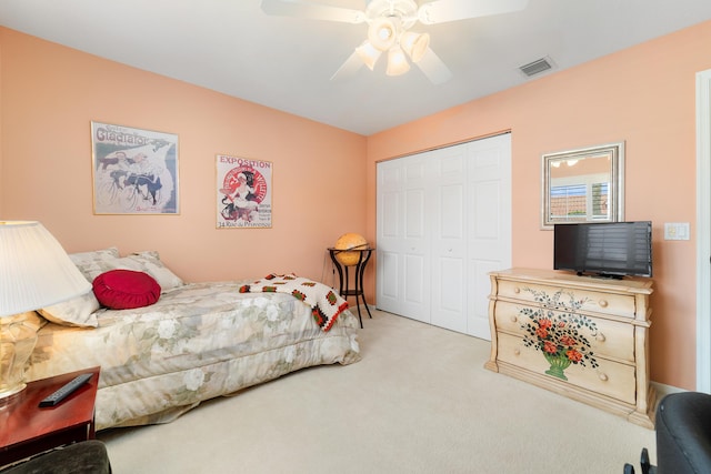 bedroom with ceiling fan, light colored carpet, and a closet