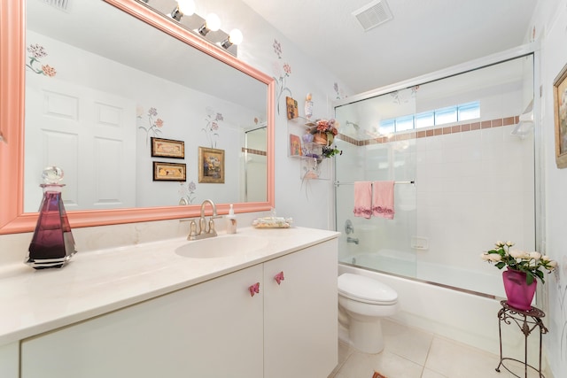 full bathroom with toilet, tile patterned floors, enclosed tub / shower combo, and vanity