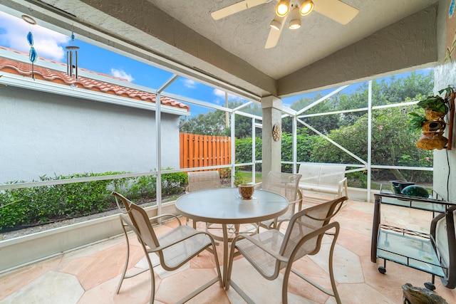 sunroom with ceiling fan and lofted ceiling