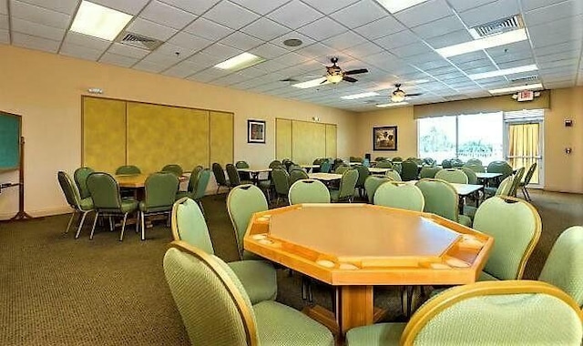 carpeted dining space featuring a paneled ceiling and ceiling fan