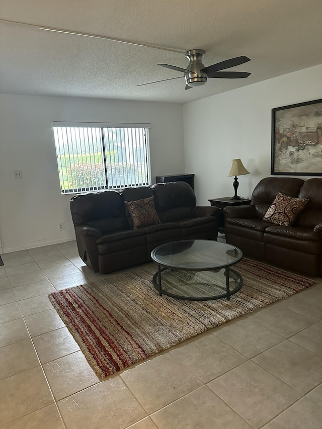 tiled living room with ceiling fan and a textured ceiling