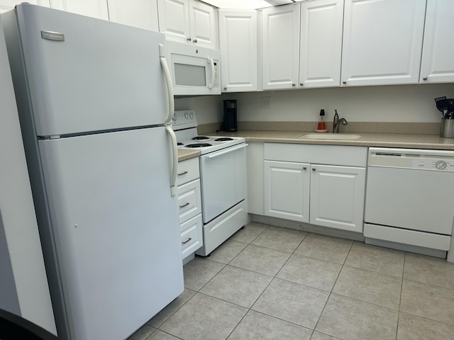 kitchen featuring white cabinets, sink, white appliances, and light tile patterned flooring