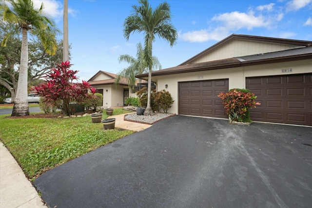 ranch-style house with a garage and a front lawn